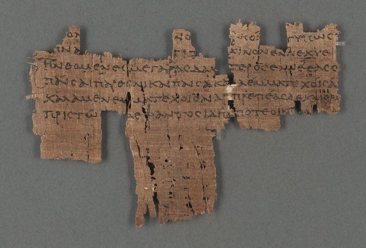 A brown papyrus fragment with several lines of Greek text.