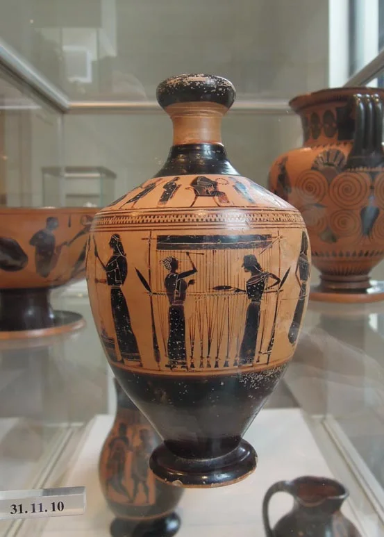 Black-figure oil flask in a case: women spin, weigh and weave wool round its body.