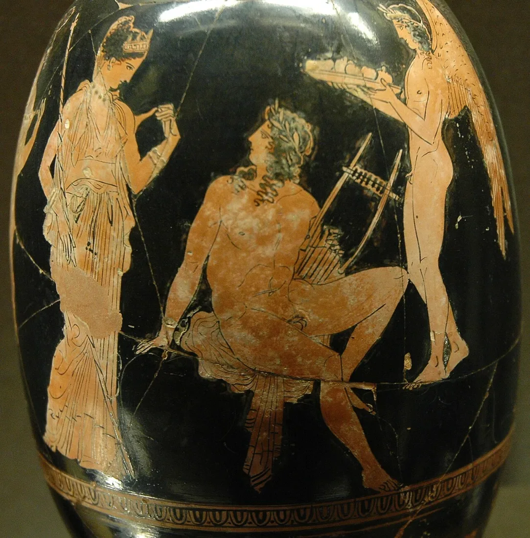 A red-figure vase: a young man with a lyre seated between a woman and a winged boy.