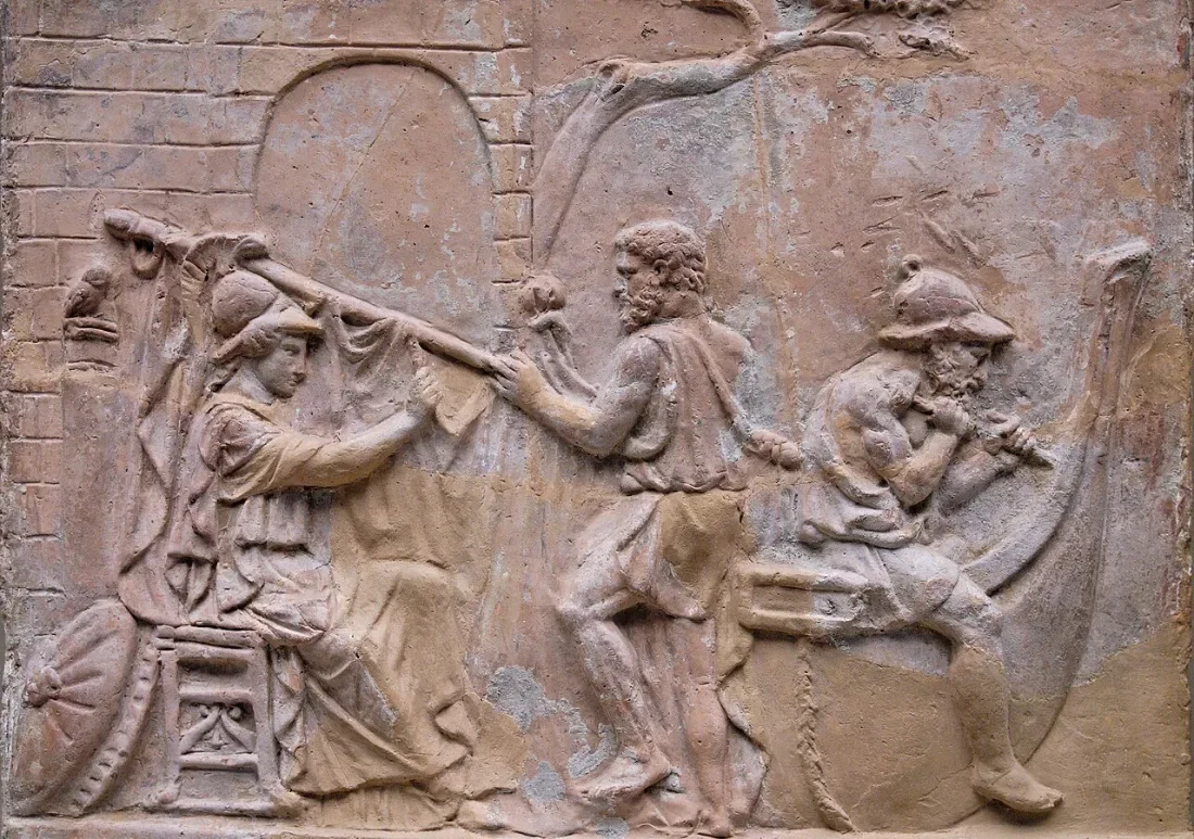 A clay relief: a goddess and two men building a ship.