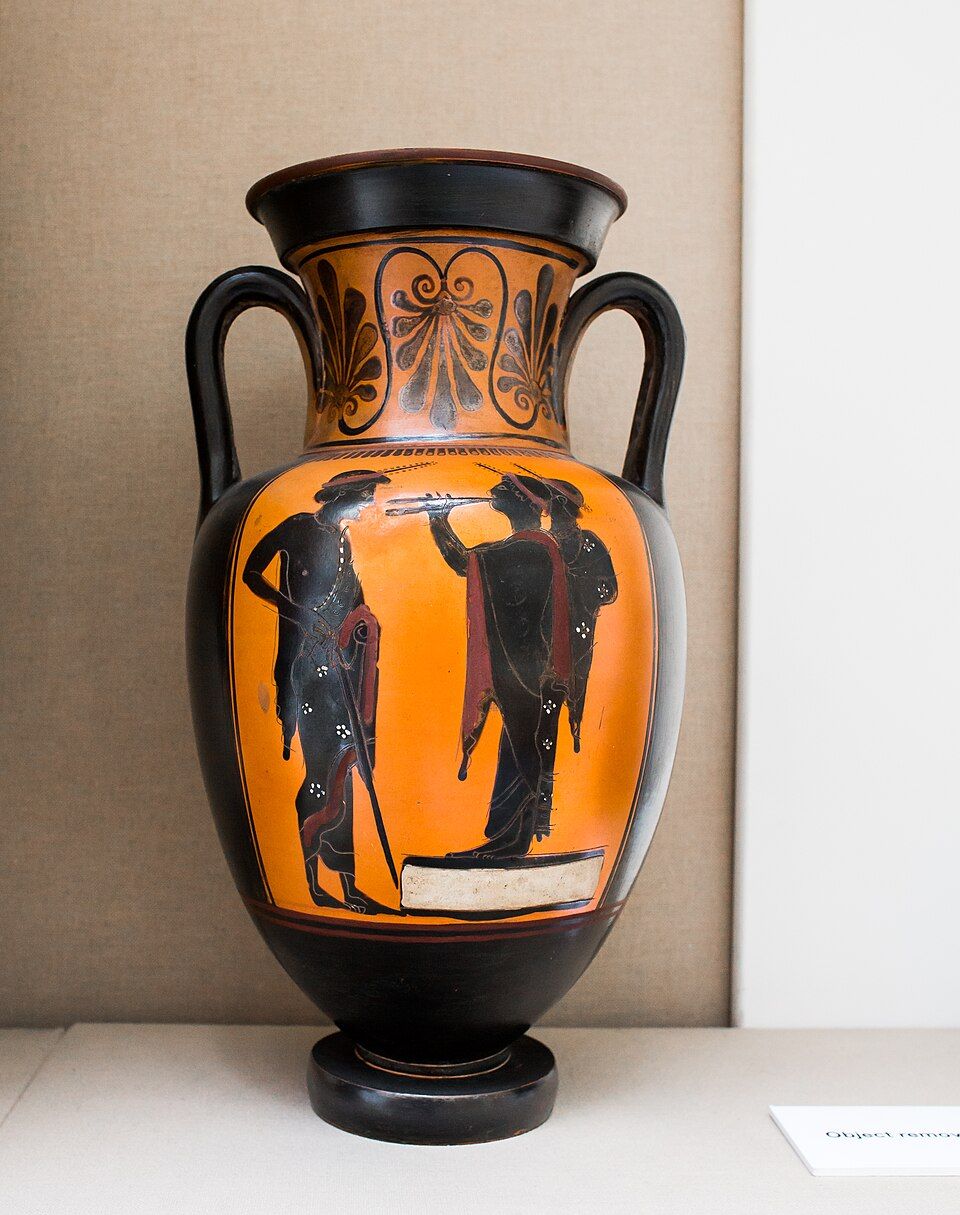 Black-figure amphora: two youths on a low platform, one playing pipes, and a draped man.