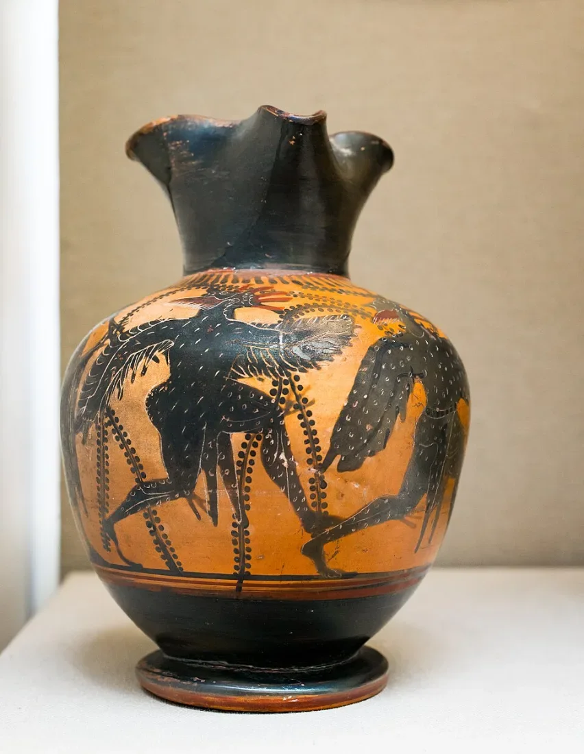 A black-figure jug: a piper and two dancers in bird costume.