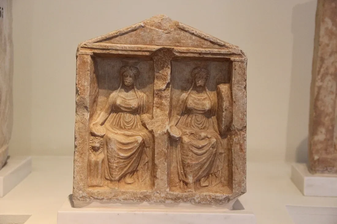 A small marble shrine with two seated goddesses.