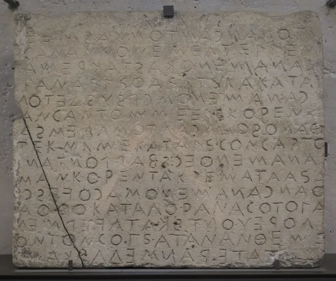A stone block inscribed with lines of archaic Greek letters.
