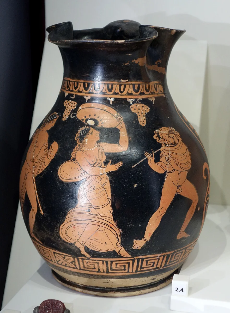 Red-figure jug: a maenad dances holding a round frame drum.