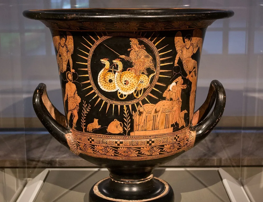 A red-figure krater: a woman in a sun-ringed chariot drawn by snakes above figures and an altar.