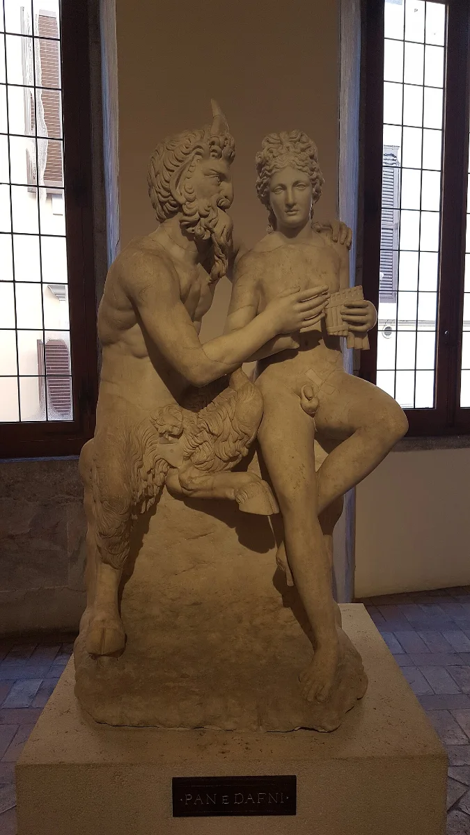 Marble group: the goat-legged Pan sits beside the young Daphnis and guides his hands on a panpipe.