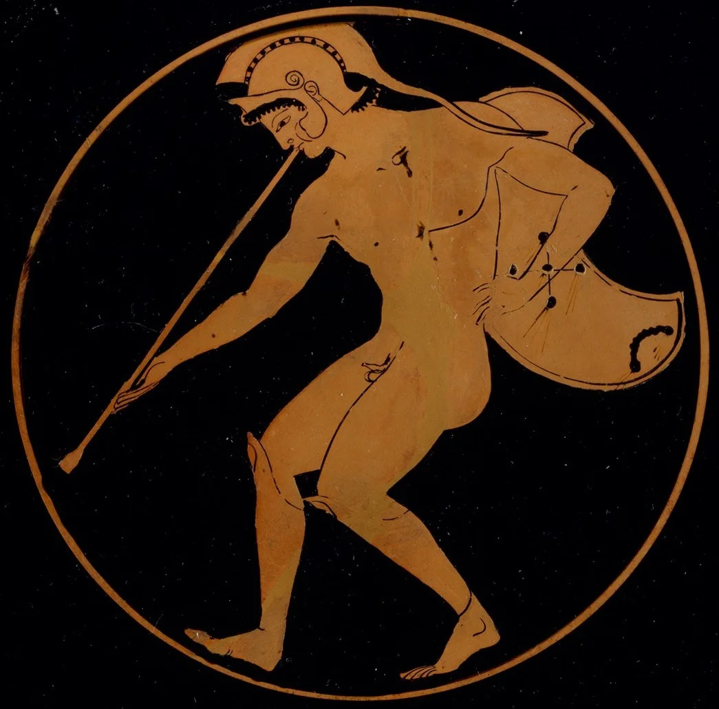 Red-figure cup interior: a helmeted man in a short cloak strides along blowing a long straight trumpet.