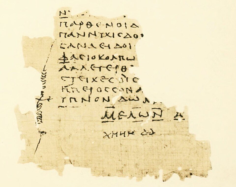Papyrus fragment with a few lines of Greek capitals and a sign in the margin.