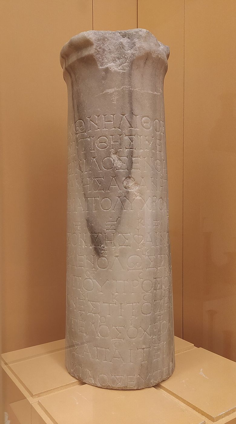 A marble column inscribed with lines of Greek text.