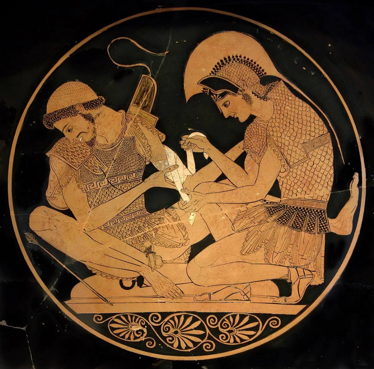 A round painting inside a cup: one warrior binds the arm of another, who sits turning his head away.