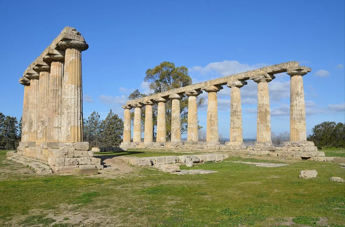 Two rows of standing Doric columns in a grassy field.