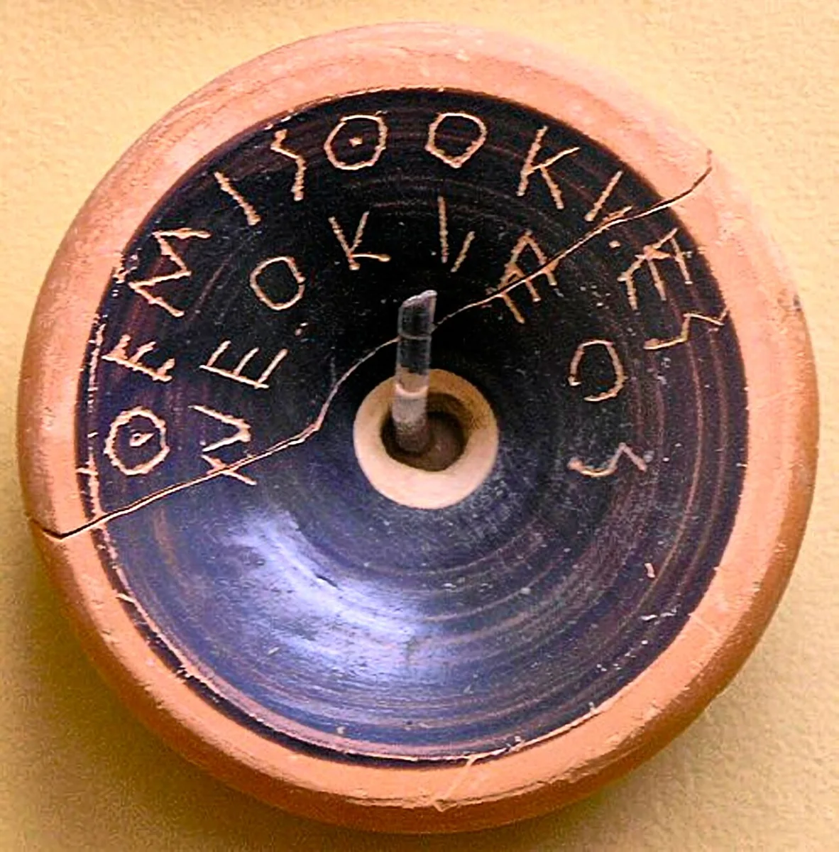 A round black-glazed potsherd scratched with Greek capitals: THEMISTHOKLES NEOKLEOS.