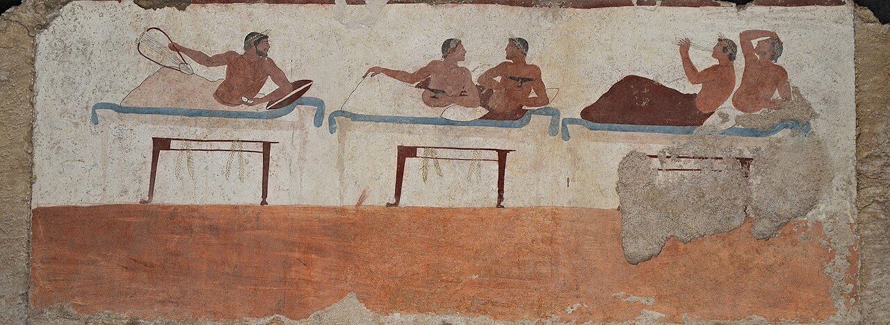 Wall painting of men reclining on couches at a drinking party.