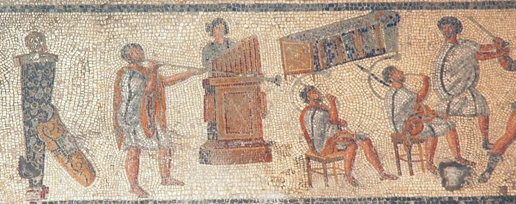 A strip of mosaic: musicians in tunics play a water organ, a large curved horn and a long straight trumpet.